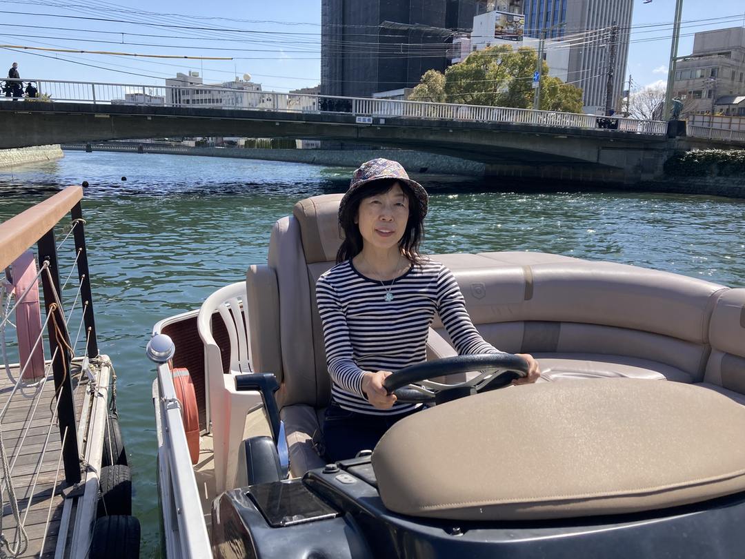 徳島の水辺でボートに乗る小畑真由美さん、2024年